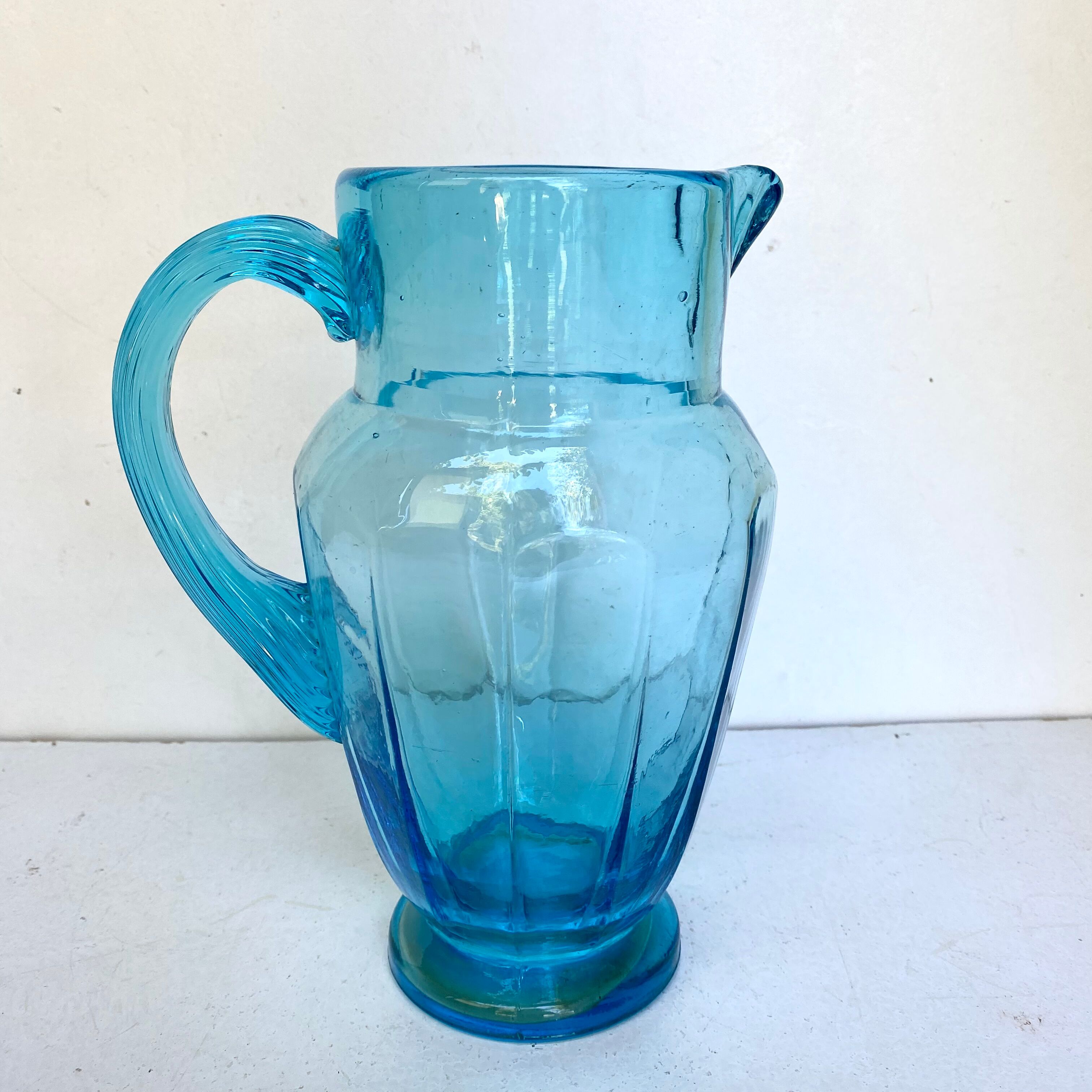 Old pitcher in blue glass