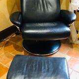 Black leather armchair stressless model jazz and its footrest