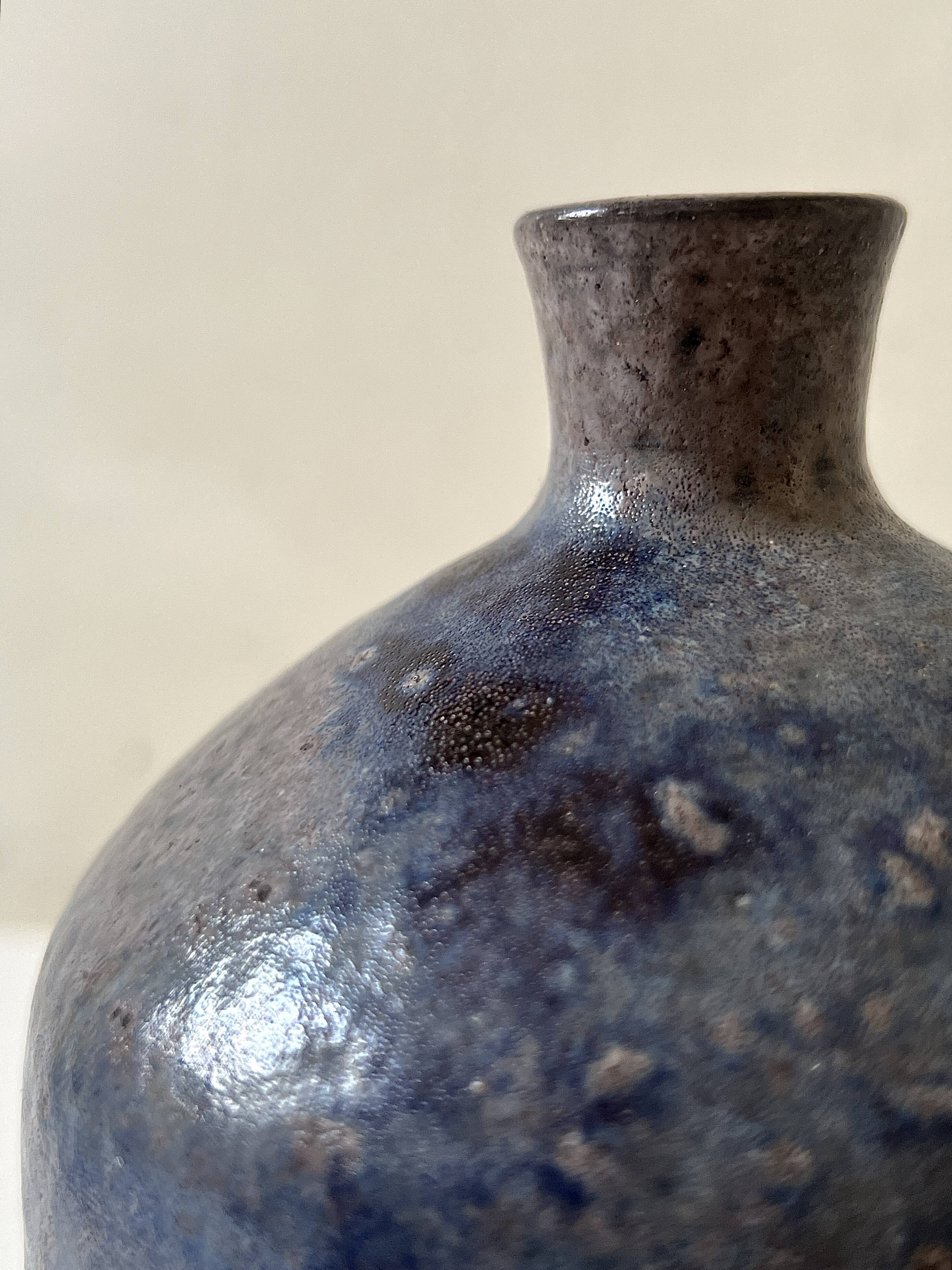 Glazed ceramic vase with a narrow neck and signed, unique piece.