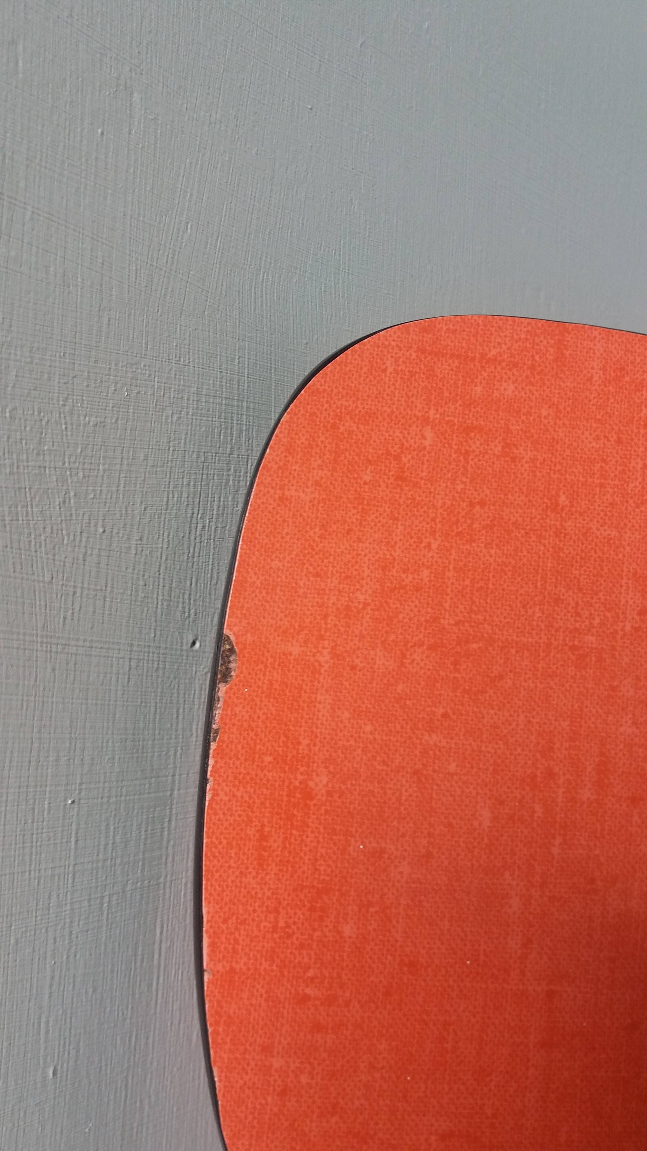 Chairs in red-orange formica and chrome metal.