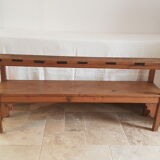 Church bench in fir tree with armrests