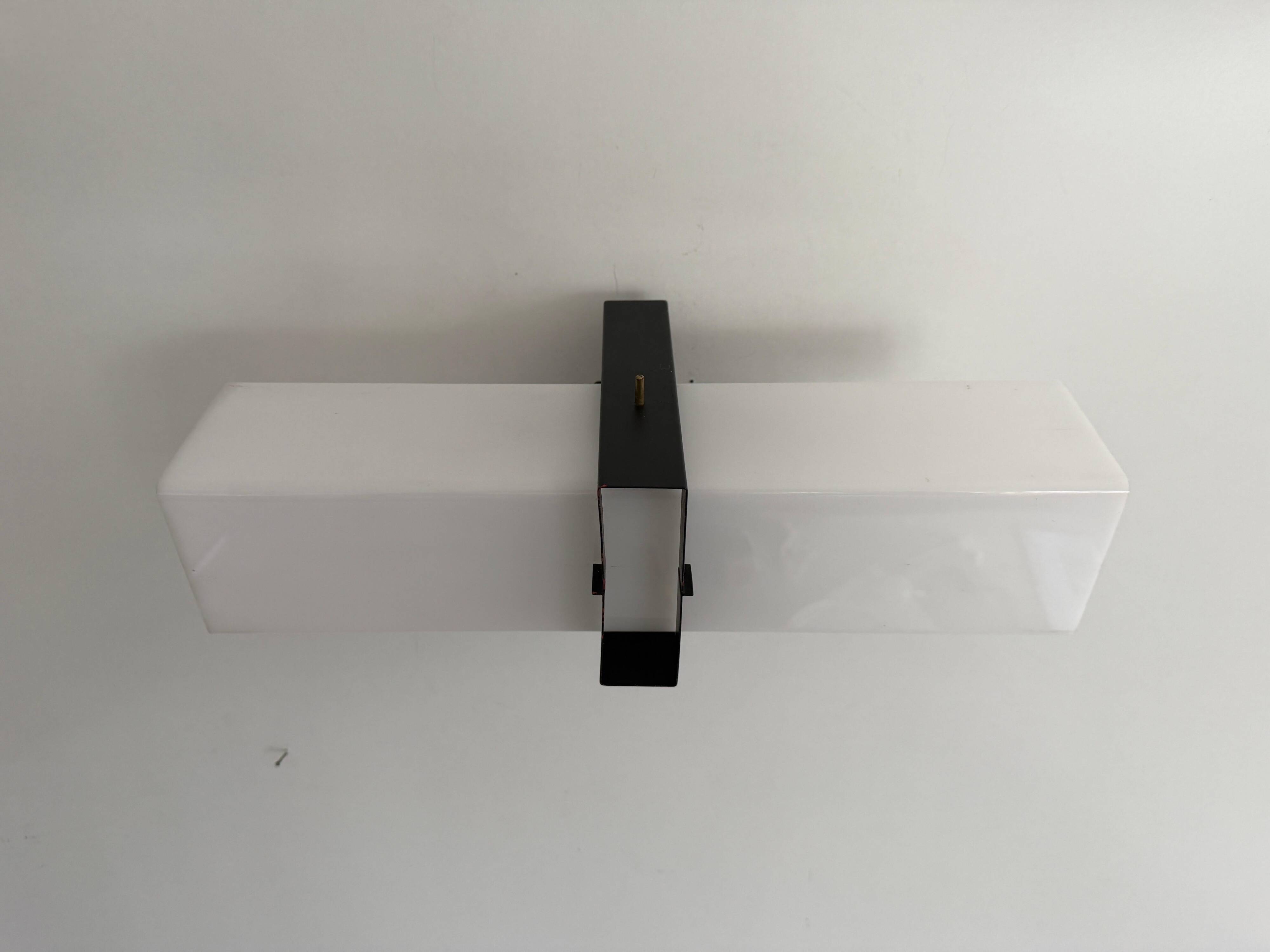 Simple white plexiglass wall light with a black metal frame, 1970s, Germany.