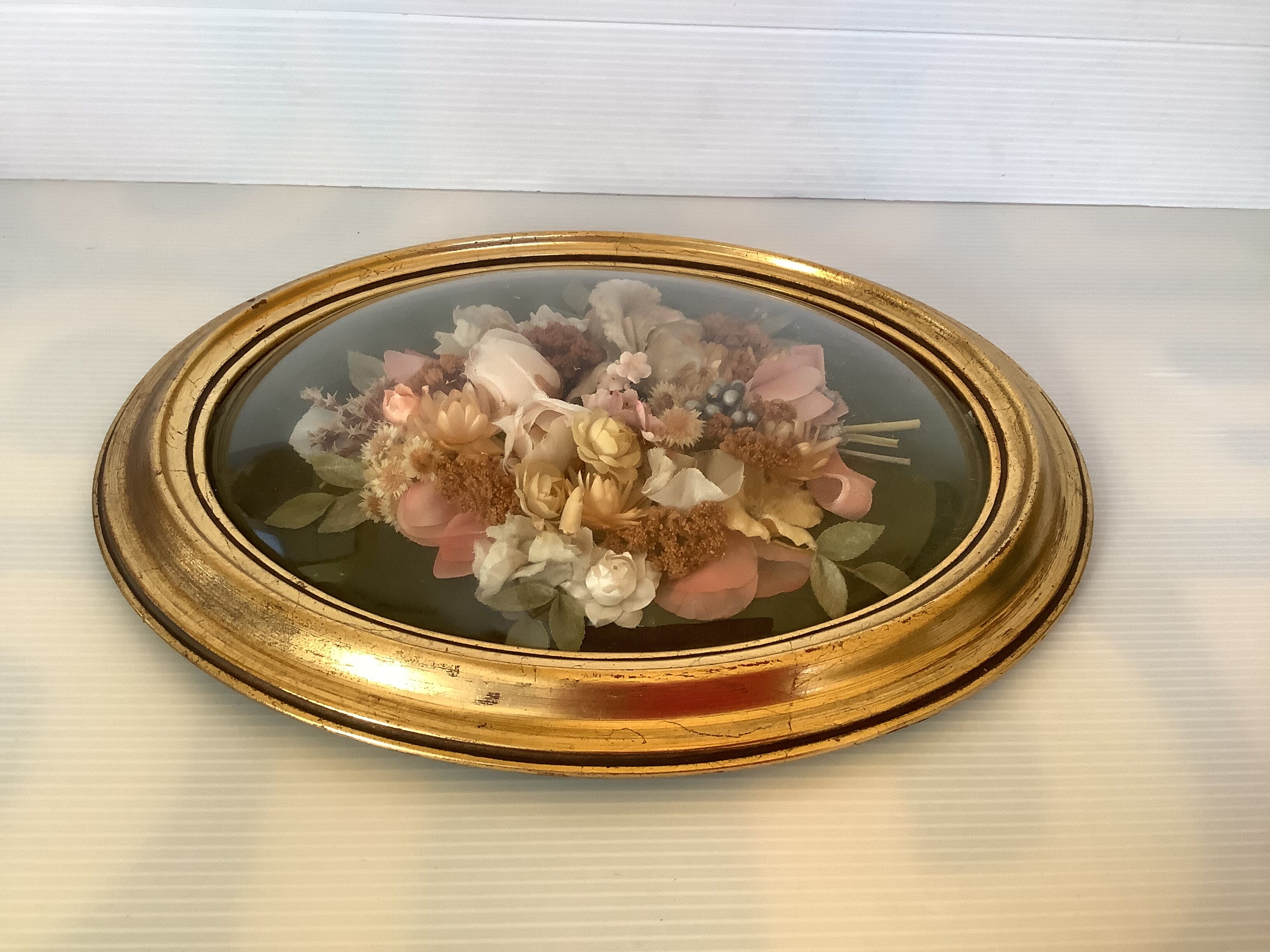 Golden oval frame dried flowers
