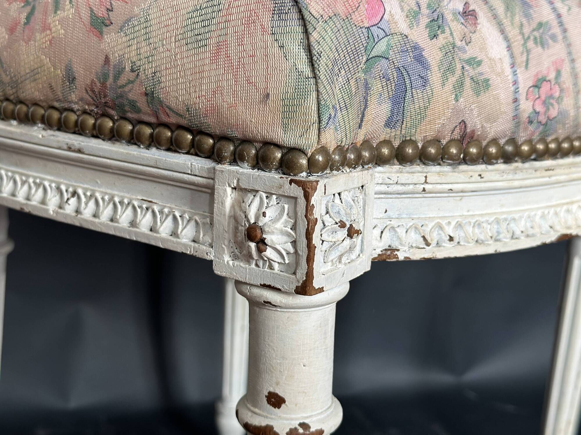 Antique Louis XVI style chair with patinated wood and floral fabric.