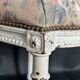 Antique Louis XVI style chair with patinated wood and floral fabric.