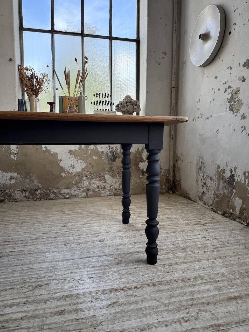 Oak farmhouse table with turned black legs.