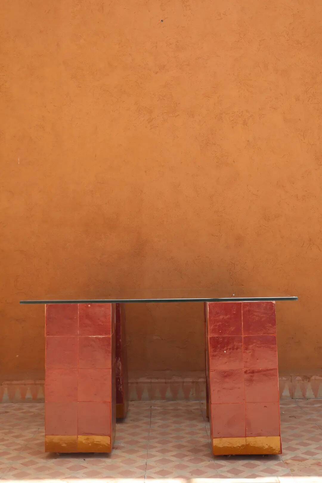 Modern coffee table in burgundy zellige with a tempered glass top.