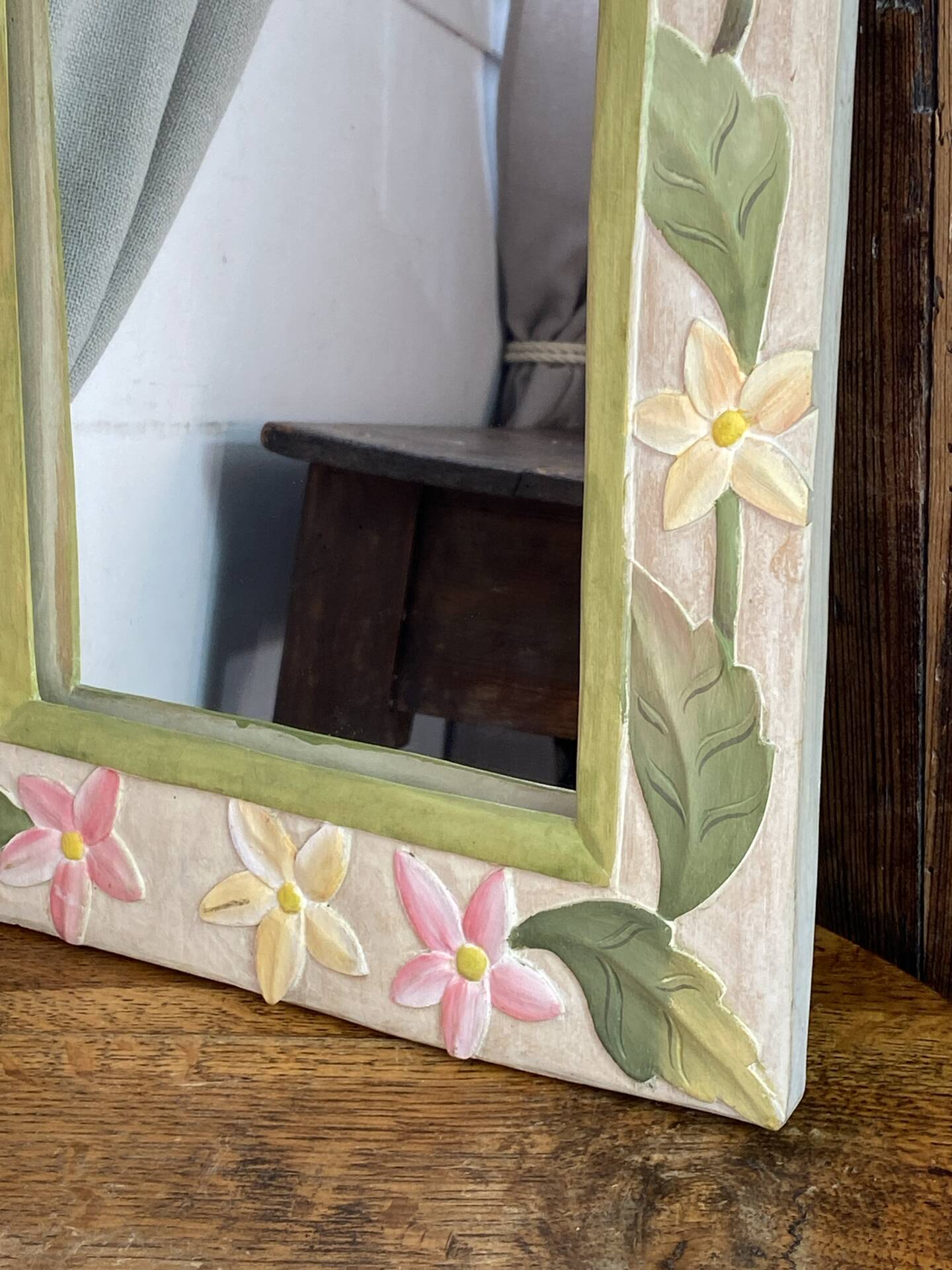 Carved wooden mirror, colourful floral decoration.