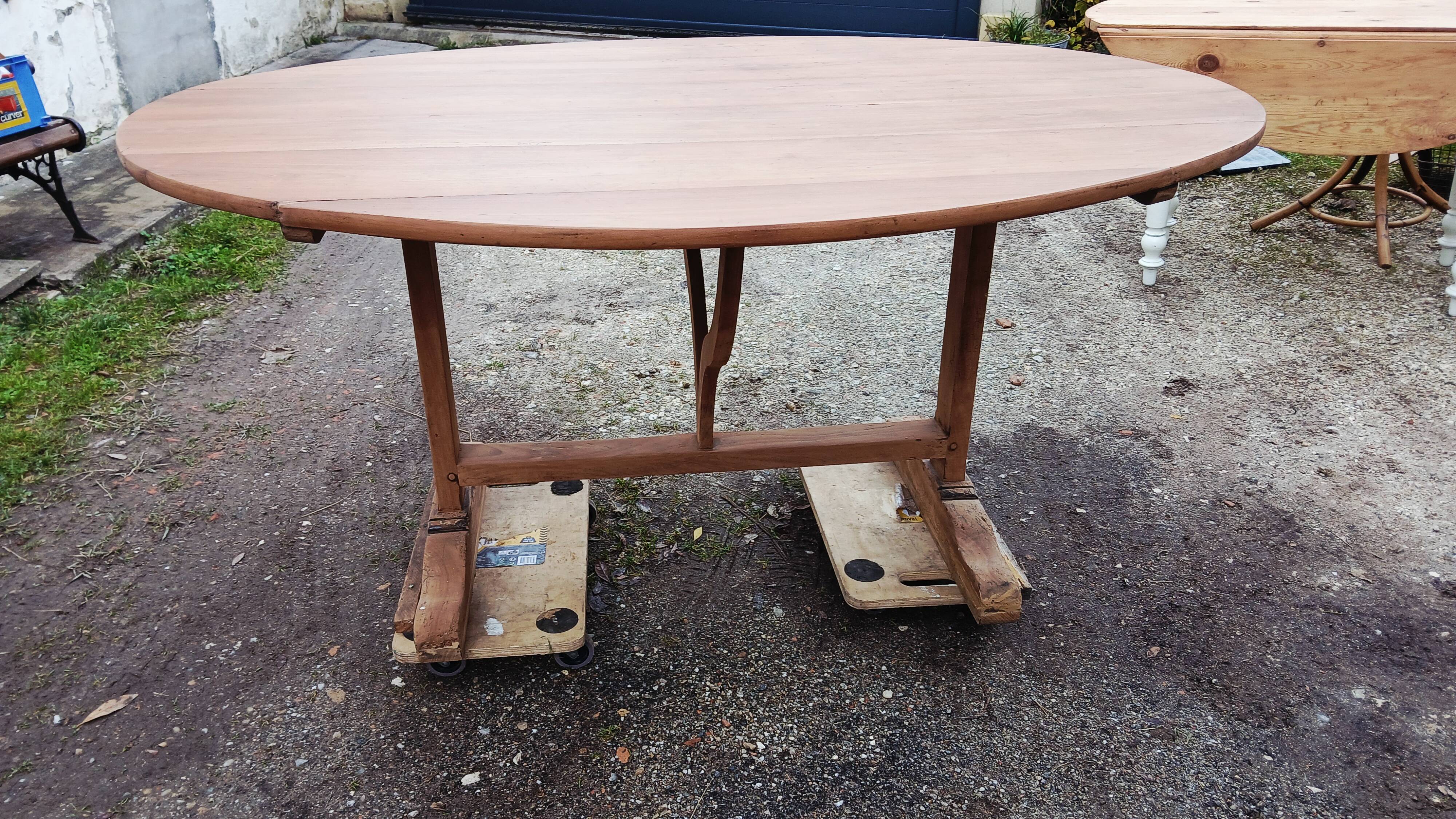 Oval table of grape harvesters from the Southwest in cherry wood