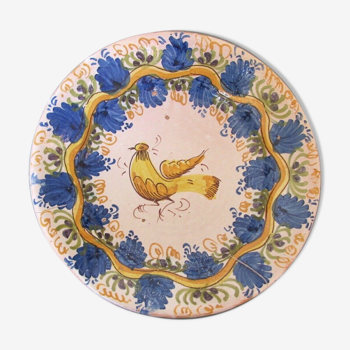 Plat en faience à décor de volatile jaune sur fond bleu