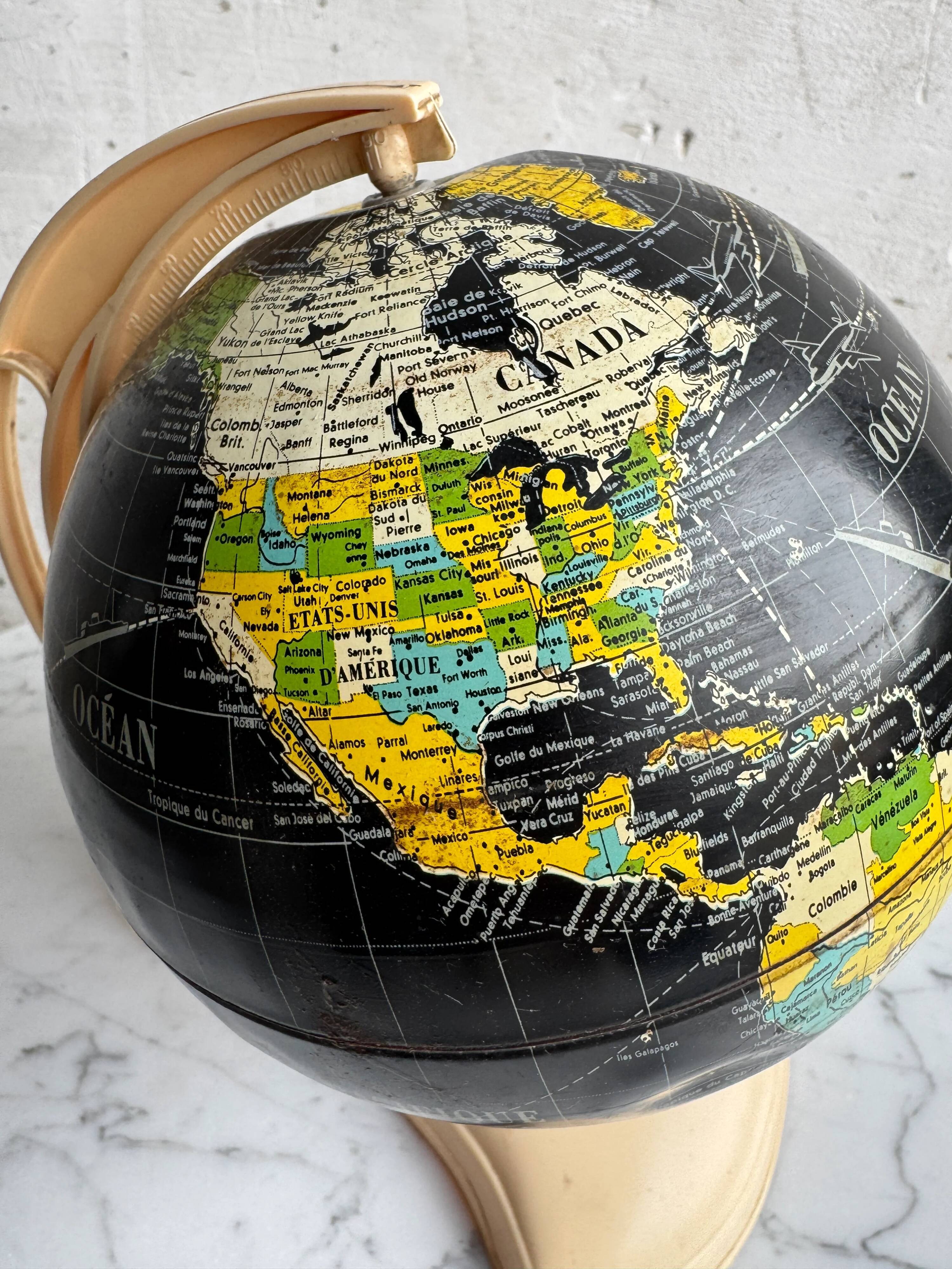French mid-century school globe with black oceans on printed paper, cream plastic base