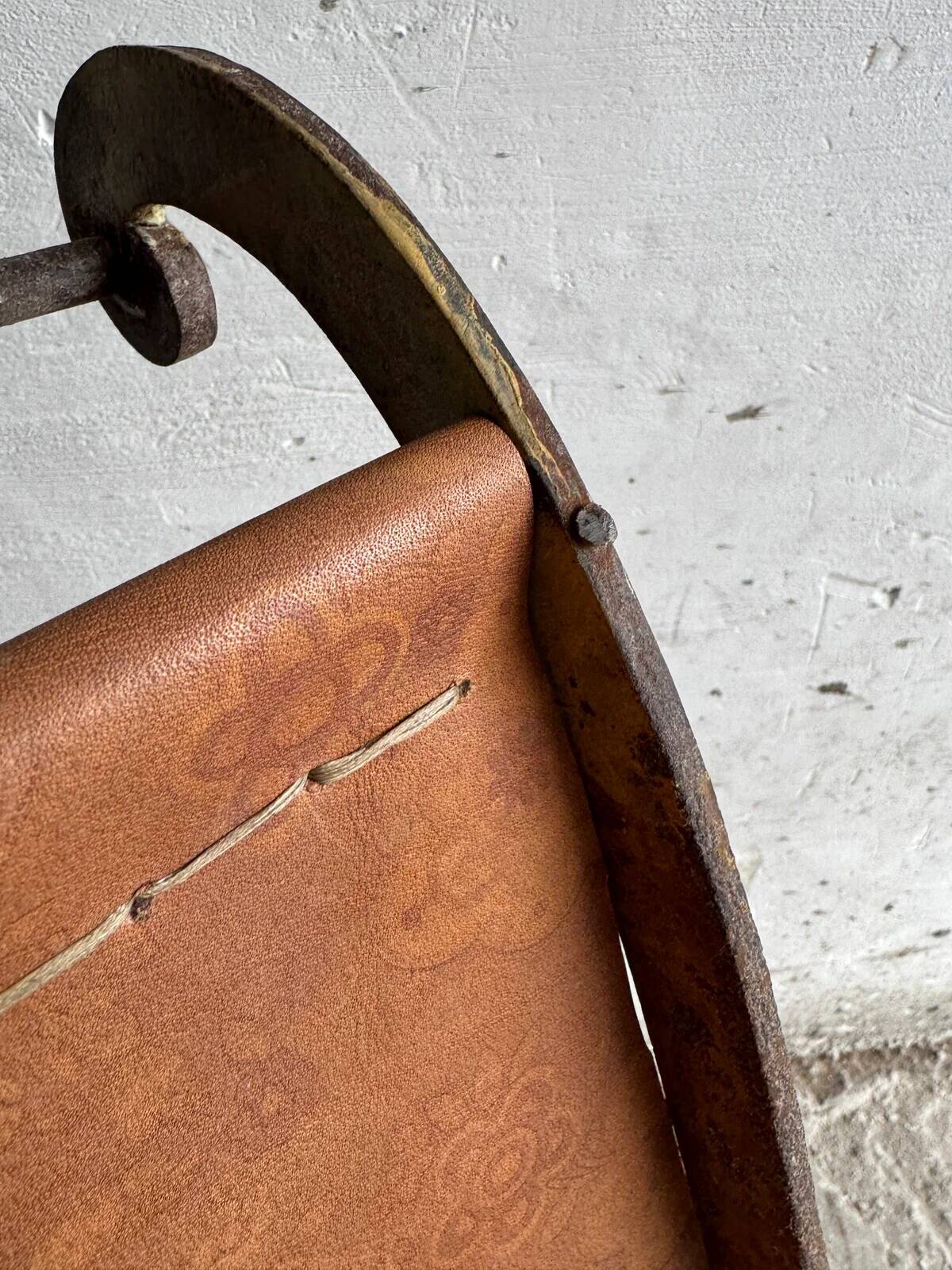 19th-century dark brown wrought-metal rocking chair with cognac leather sling seat, vintage
