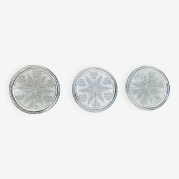 A set of three frosted glass bottle coasters