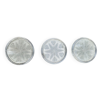 A set of three frosted glass bottle coasters