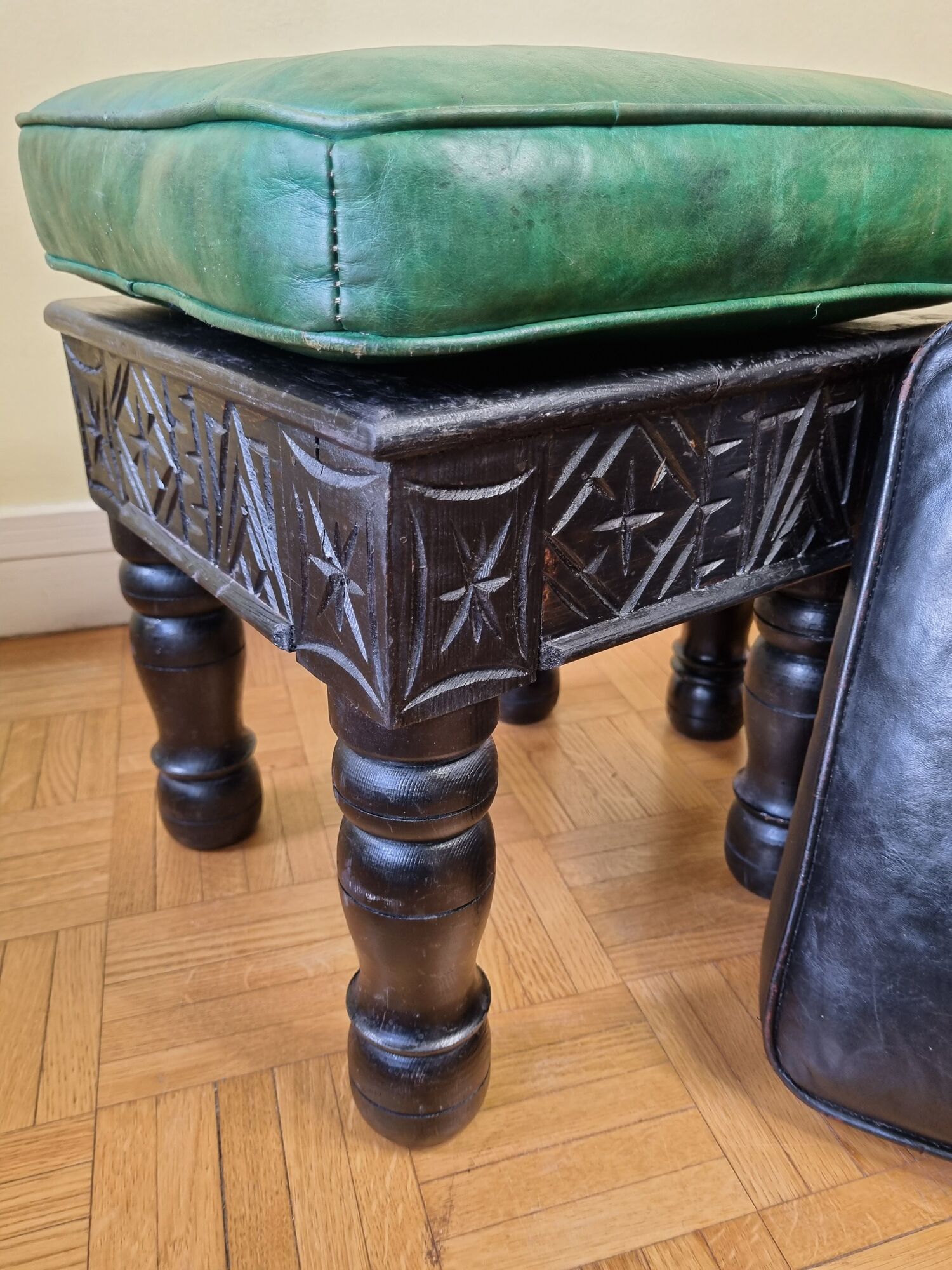Pair of Moroccan poufs in stamped leather with a carved wooden base, Rabat