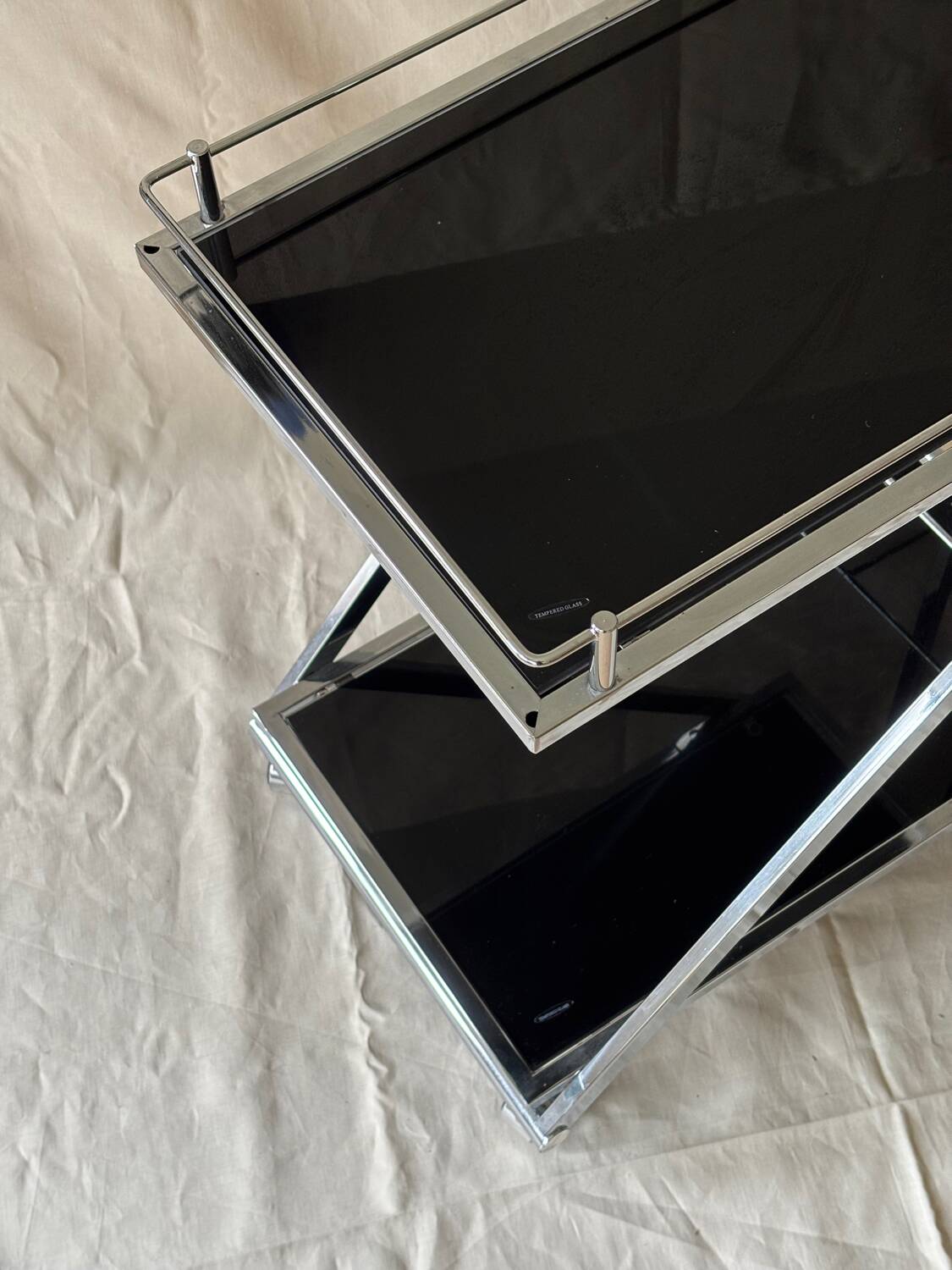 Modernist serving trolley in chromed metal and black smoked glass