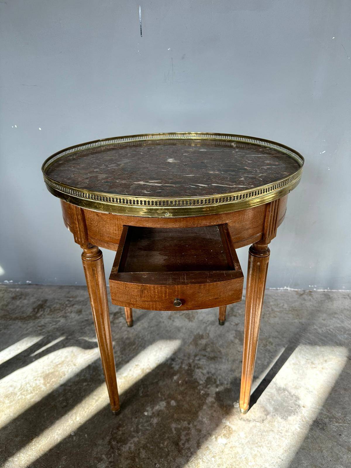 Hot water bottle table with a marble top and a brass gallery.
