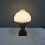 Small stylish table lamp with perforations and milky white opal glass shade