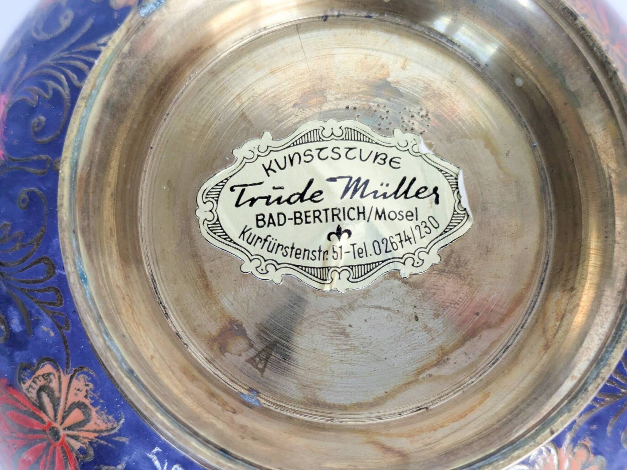 Vintage brass bowl with peacock motif, painted enamel, scalloped edge on a pedestal.