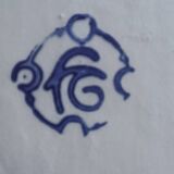 Footed dessert plate in barbotine porcelain, marked FG.