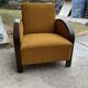 Art Deco armchair from the 1920s in straw yellow fabric and dark wood, with curved armrests.