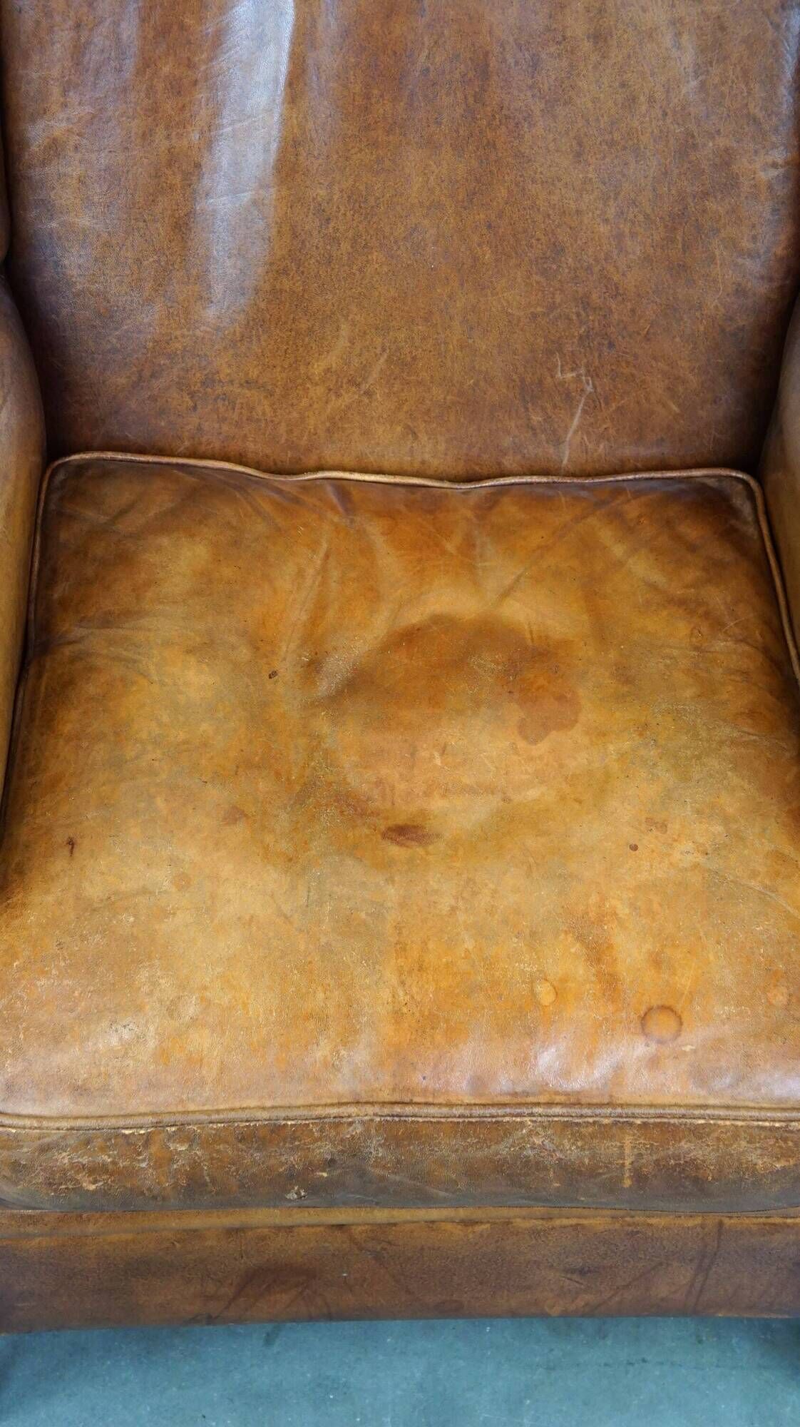 Positively lived-in sheepskin leather wing chair with pleasant seating comfort