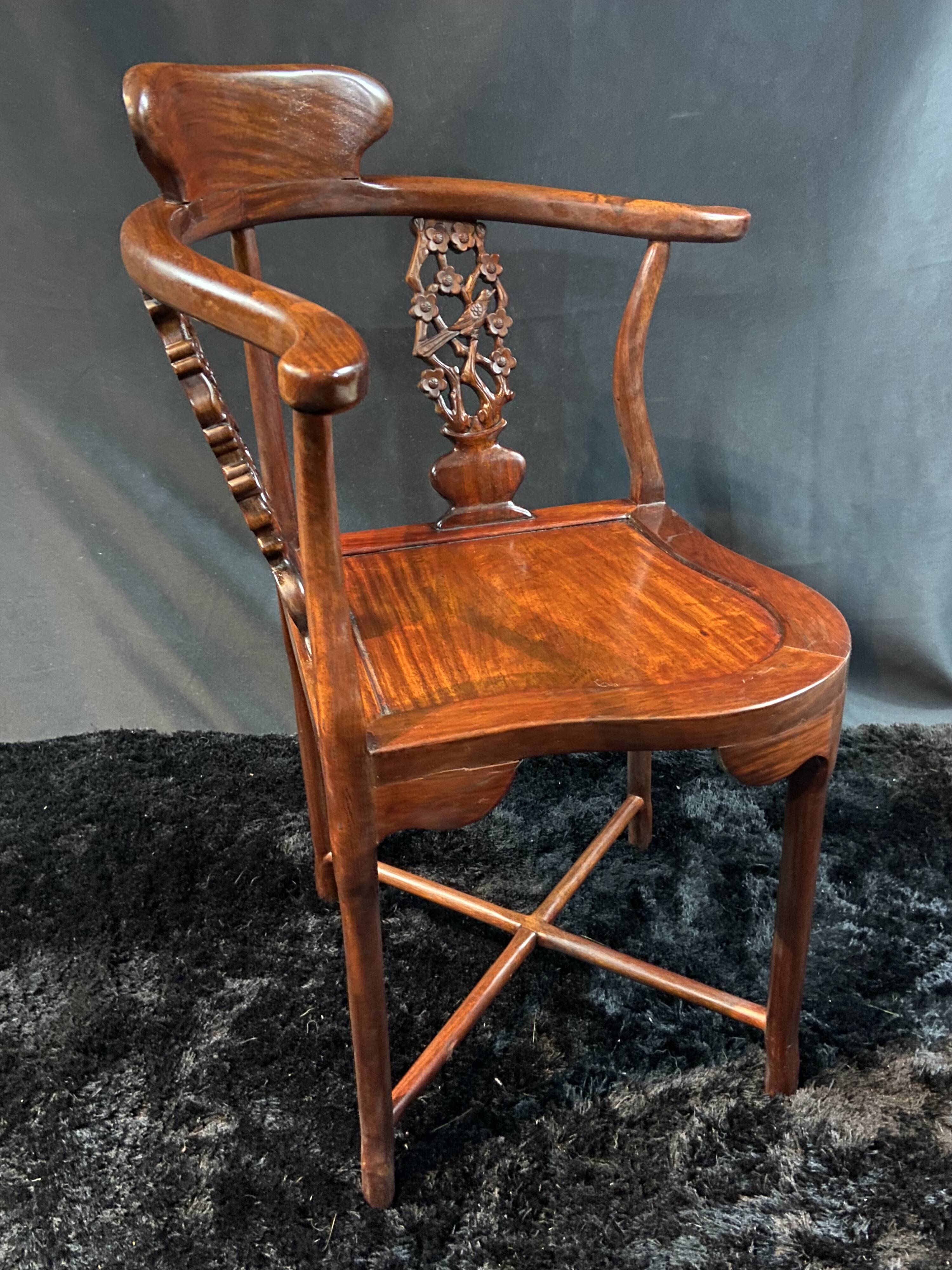 Corner armchair in solid wood with carved floral decoration featuring a bird.