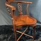 Corner armchair in solid wood with carved floral decoration featuring a bird.