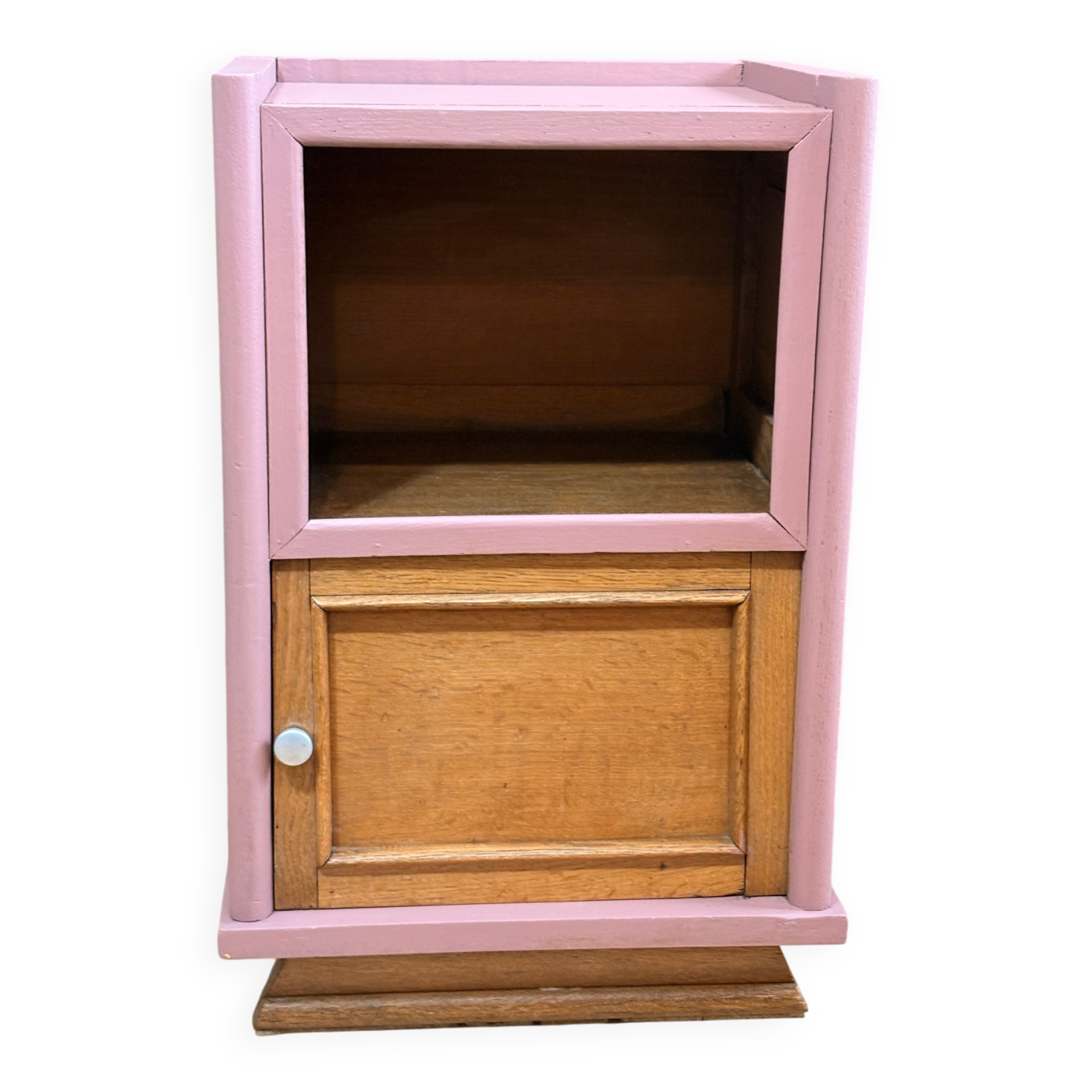 Pink bedside table with haberdashery and raw wood.
