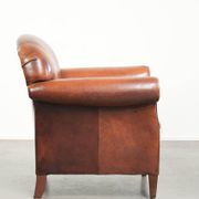 Comfortable vintage sheepskin armchair finished with decorative nails