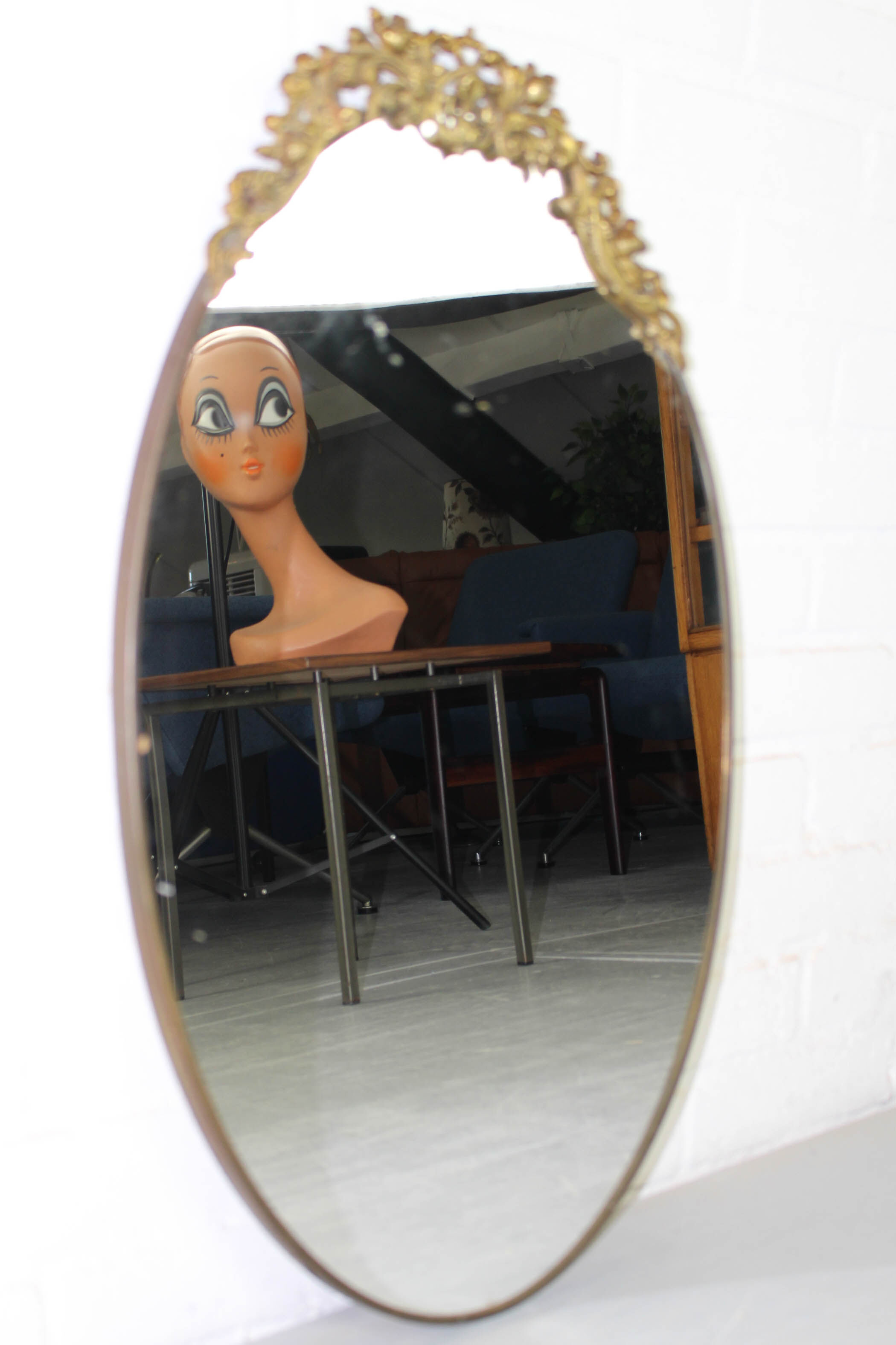 Miroir mural ovale antique dans un cadre en laiton avec ornement supérieur