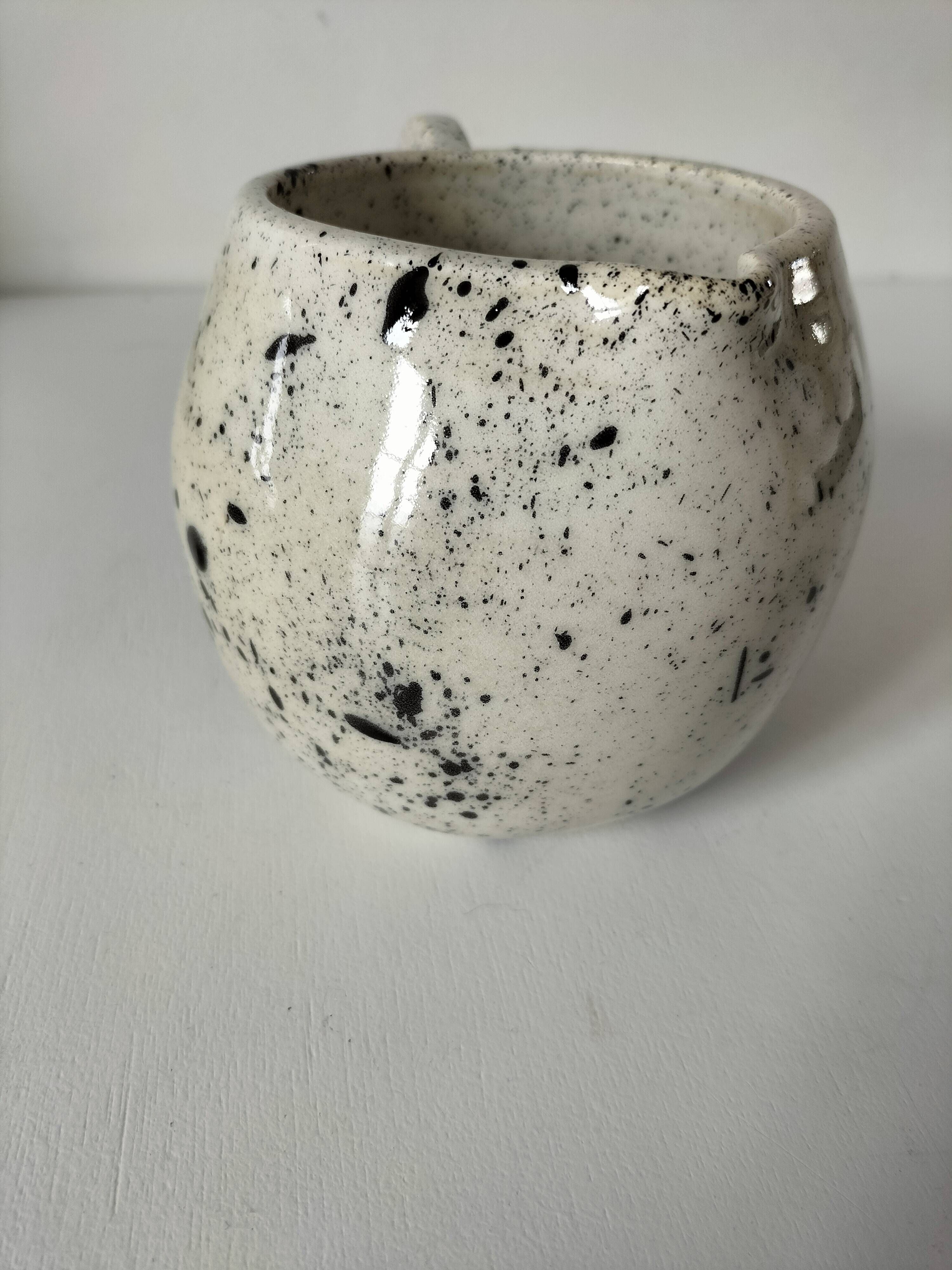 Small speckled ceramic jug in a vintage workshop style.