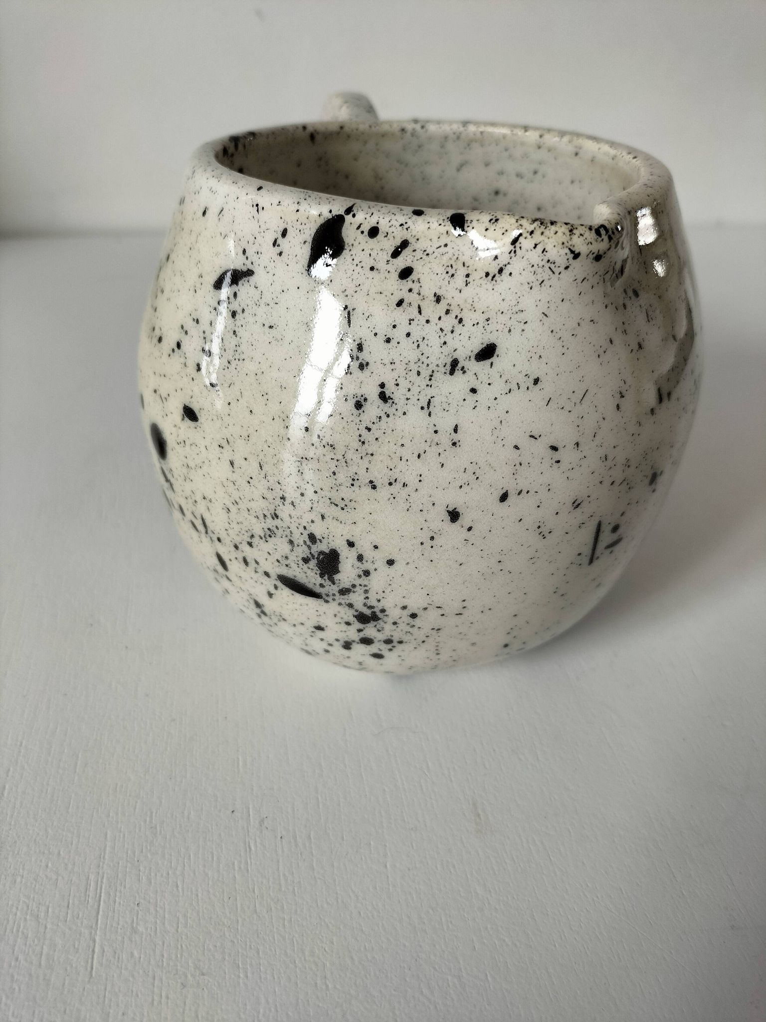 Small speckled ceramic jug in a vintage workshop style.