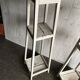 Two white vintage mid-20th century wooden plant stands, 3-tier shelves.