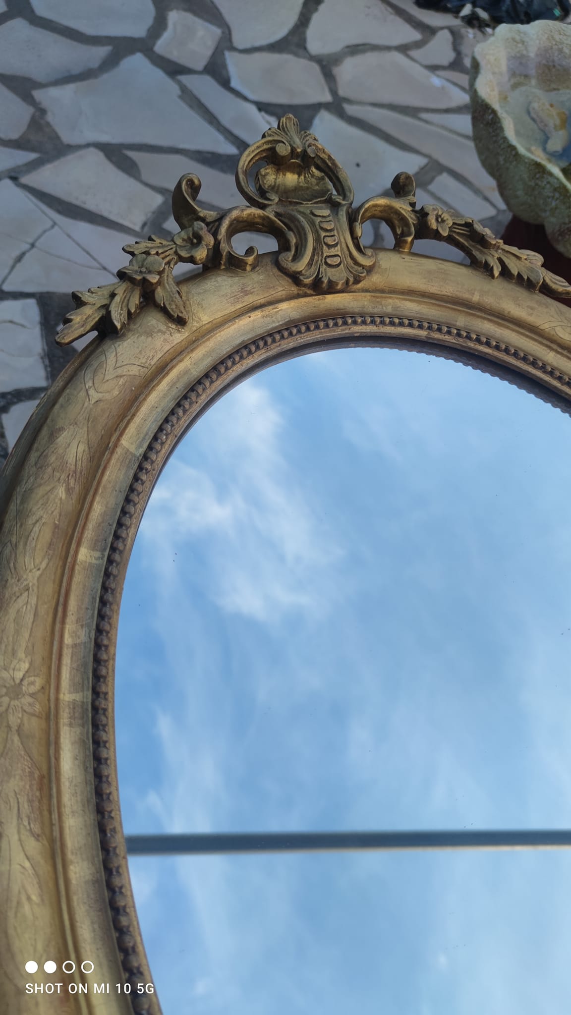 Ovoid mirror with double gilt pediments, circa 1830, 105x66 cm
