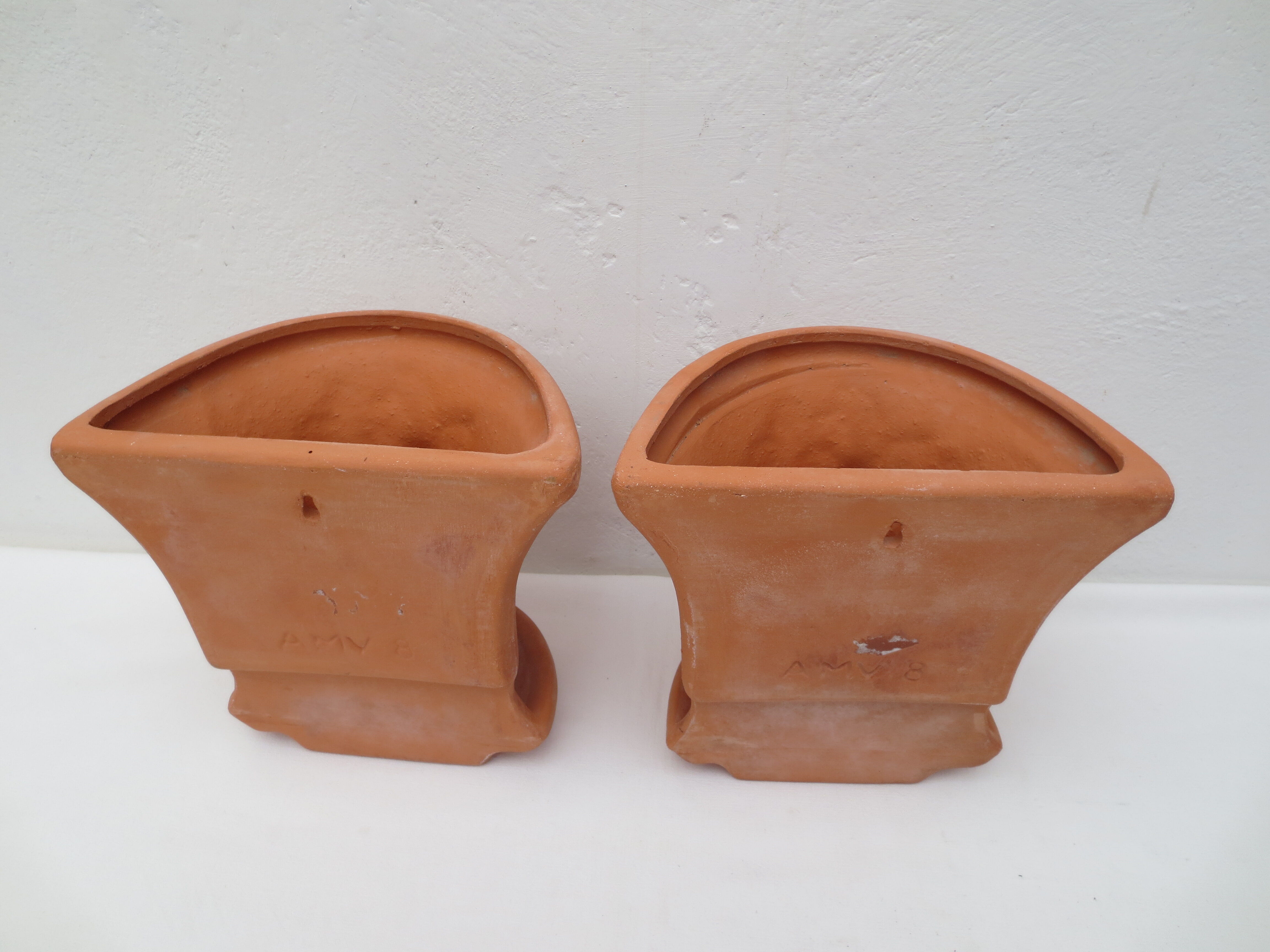 Duo of decorated terracotta wall flowerpots
