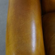 Comfortable large yellow English-style leather armchair with a fine finish and decorative nails
