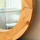 Round mirror in raw wood