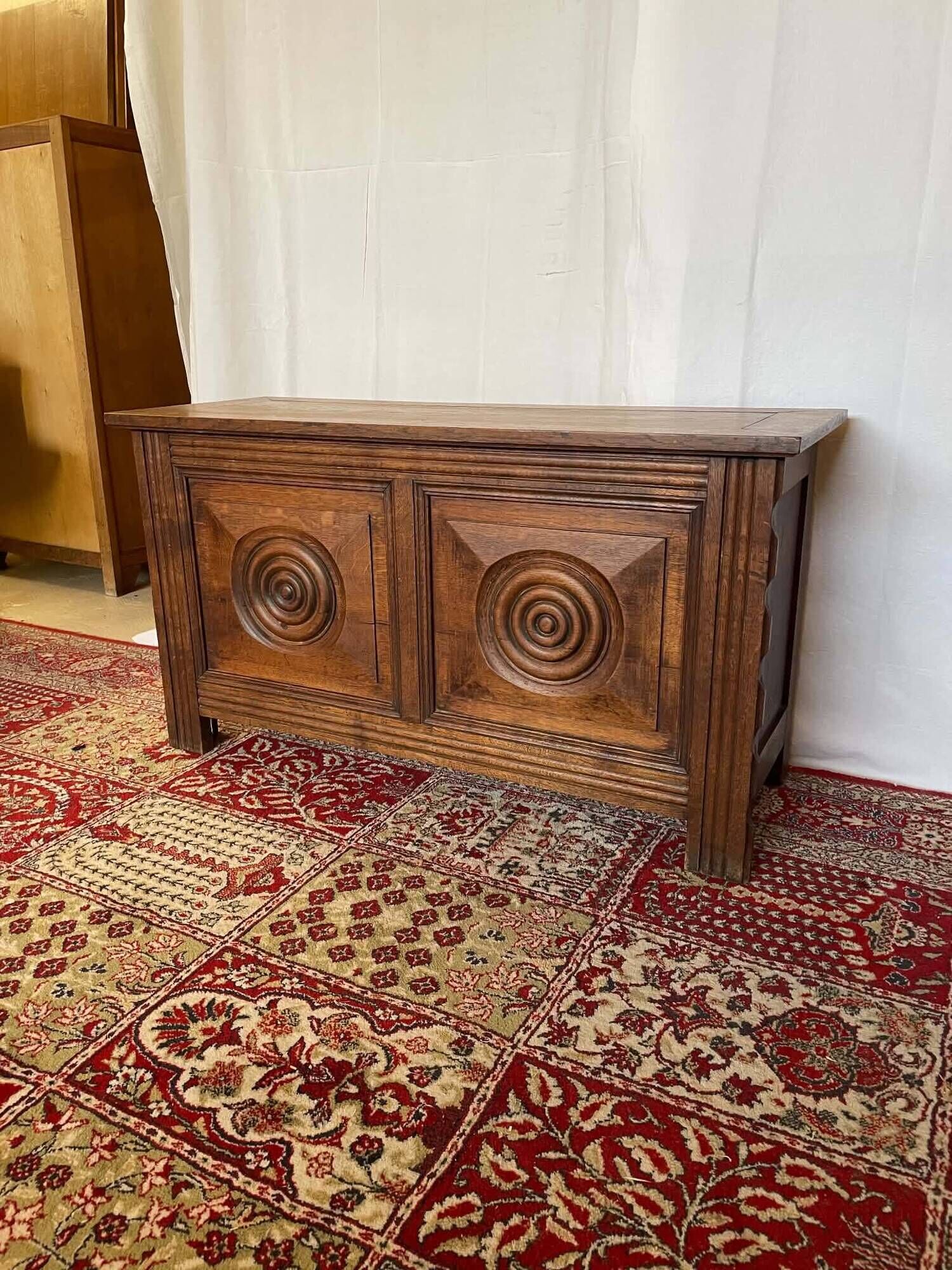 Small antique oak chest with carved panels.