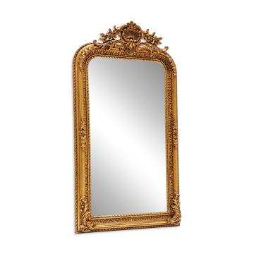 Grand miroir baroque en or avec un crête orné.