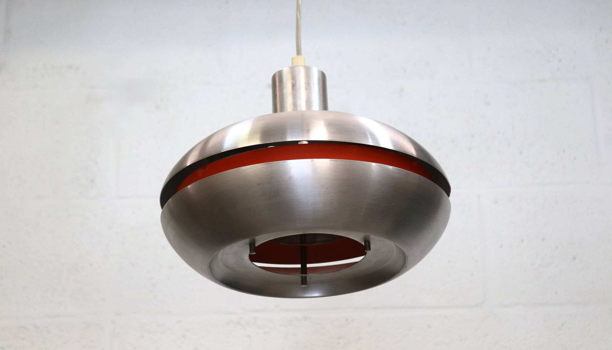 Ancienne lampe de design danois de l'ère spatiale en aluminium avec intérieur orange.