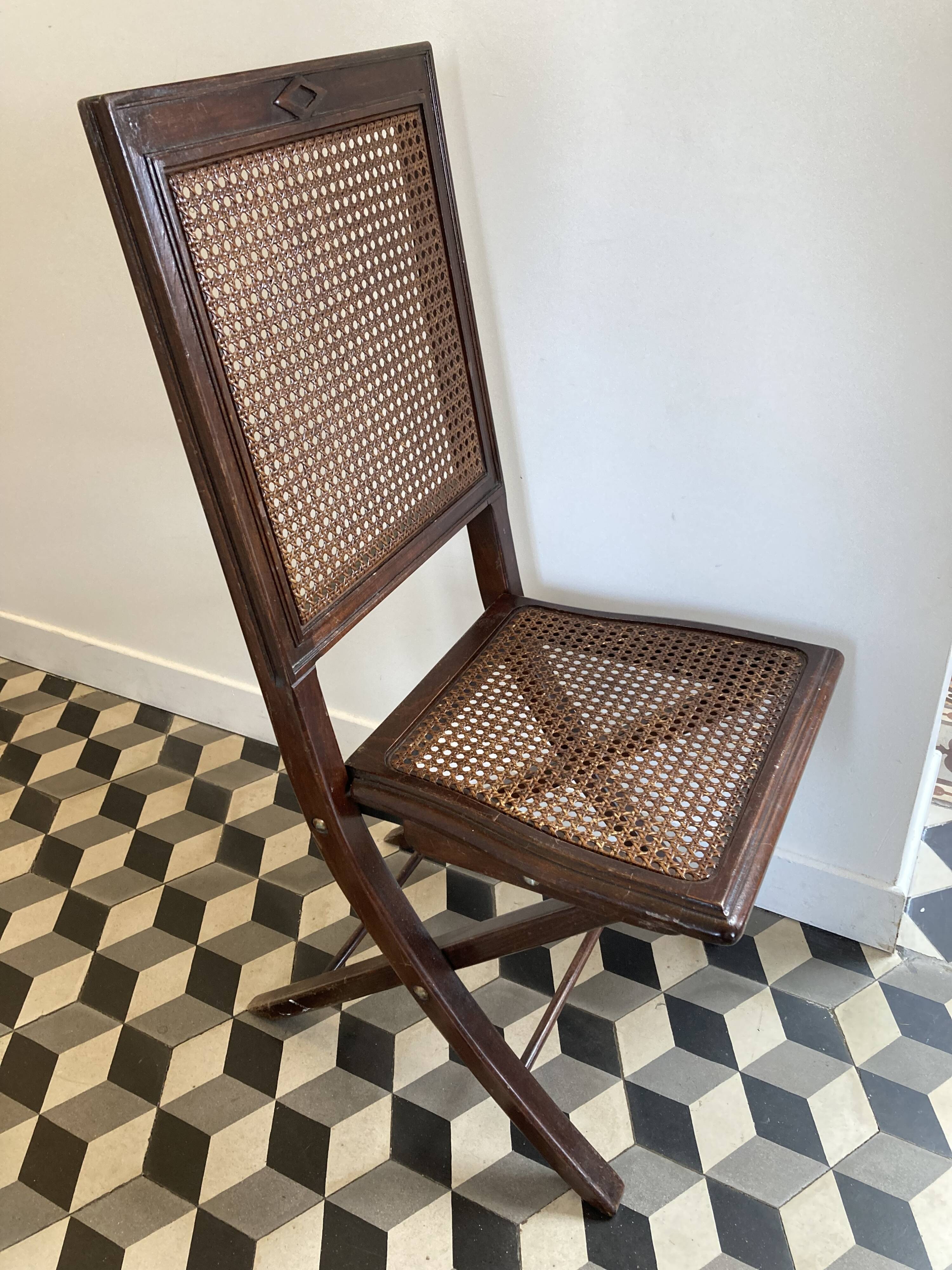 Vintage folding chair with cane seat in dark mahogany wood