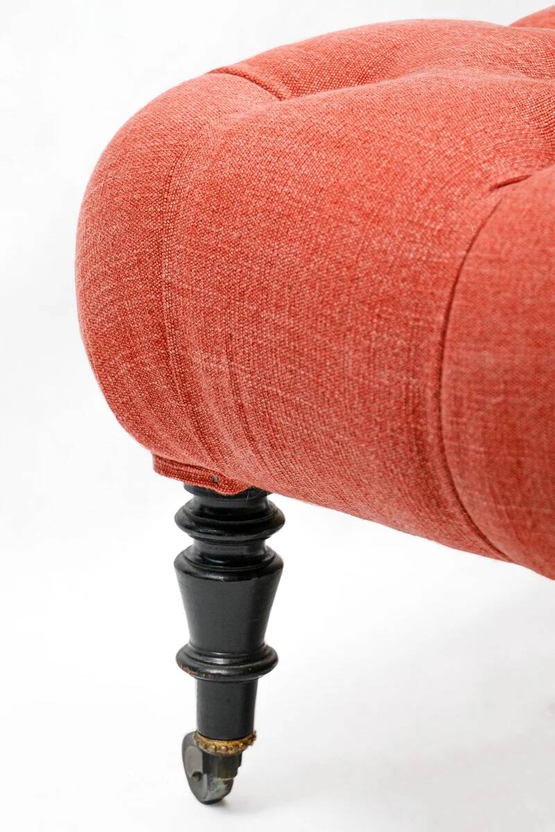 Napoleon III salon armchair in brick red linen with a tufted footrest.