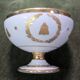 Empire-style footed cup in white porcelain, richly decorated with fine gold.