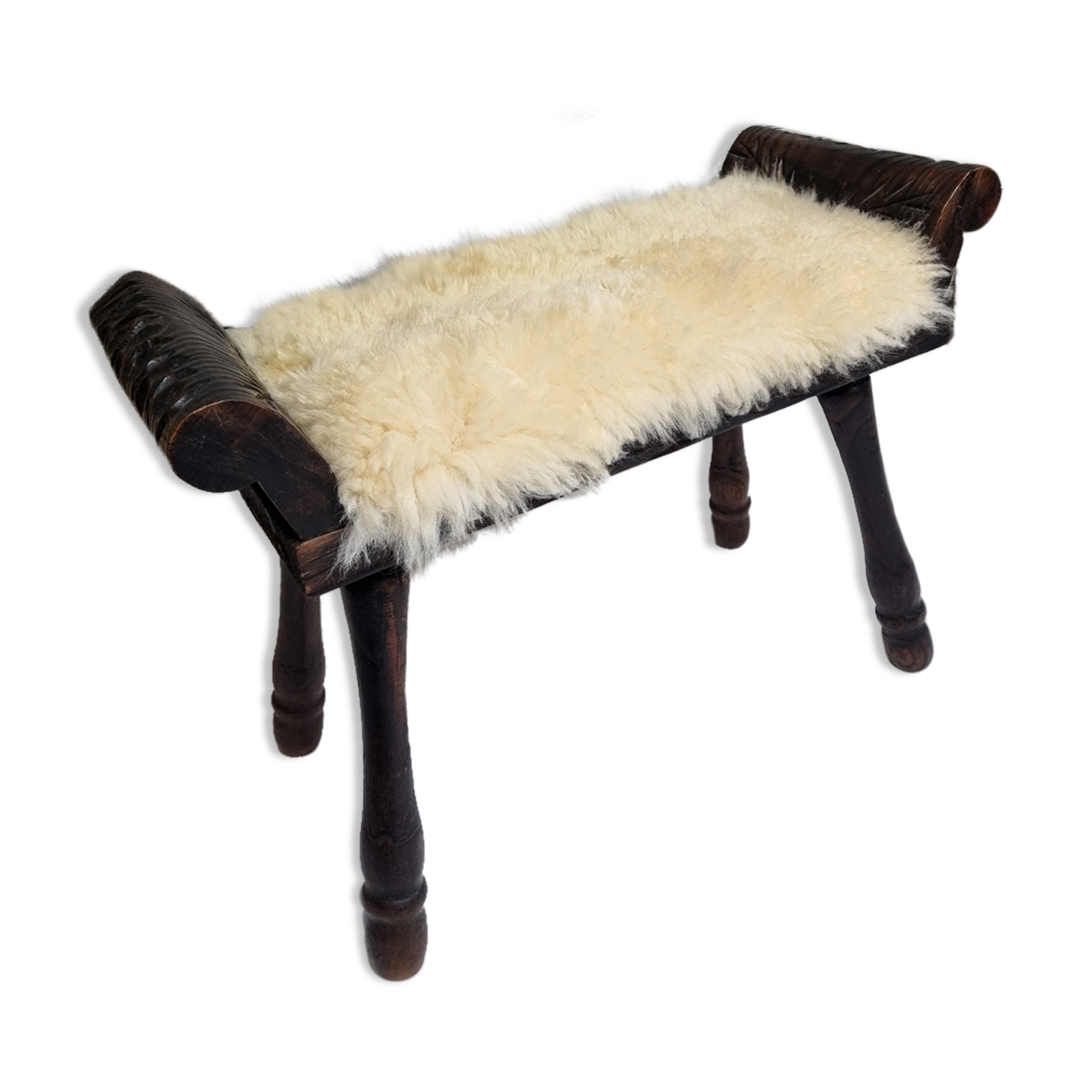 Carved wooden stool covered with Celtic-style sheepskin