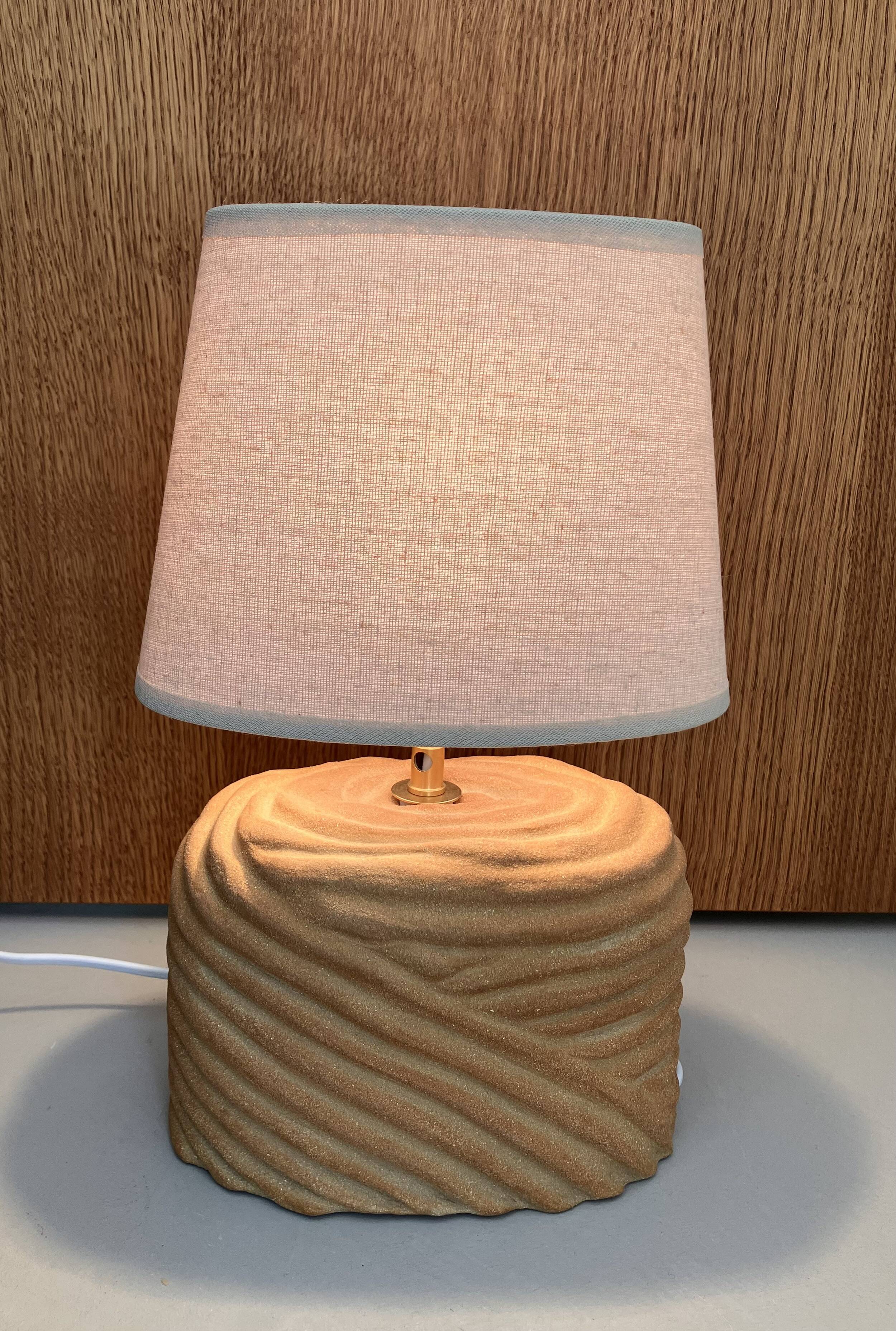 Oval table lamp in handcrafted ceramic with draped effect.