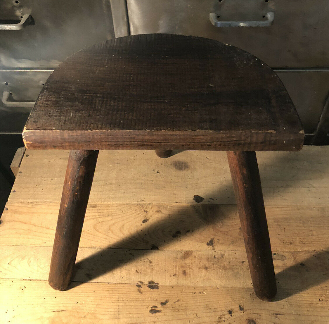 Wooden milking stool on tripod base
