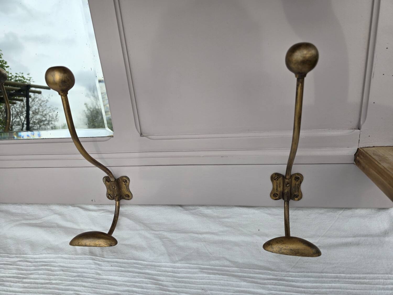 Coat rack or wall-mounted entrance wardrobe with scroll arms and antique hooks.