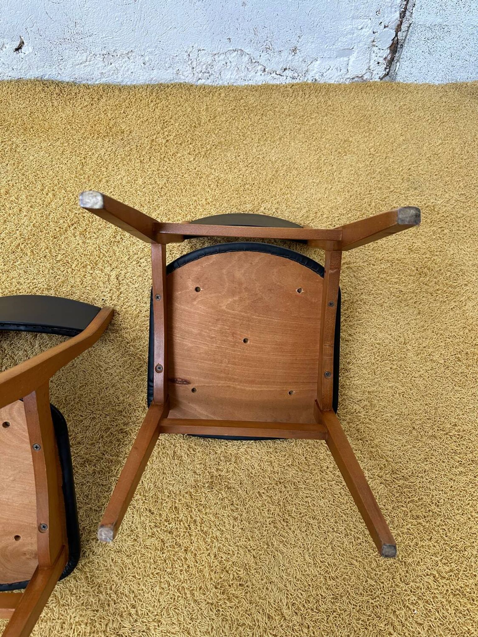 4 Scandinavian chairs in teak and black faux leather.