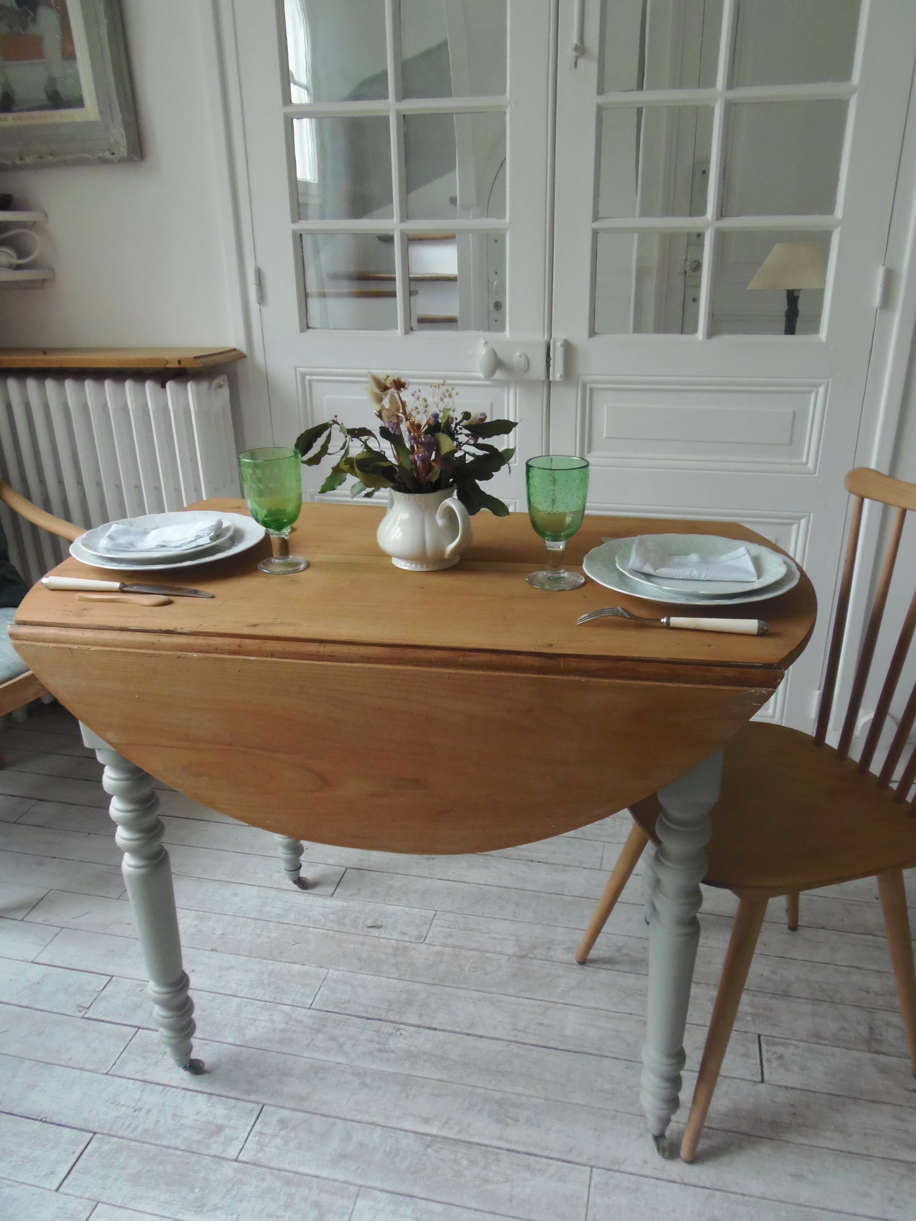 Walnut table with raised flaps, base on verdigris casters.